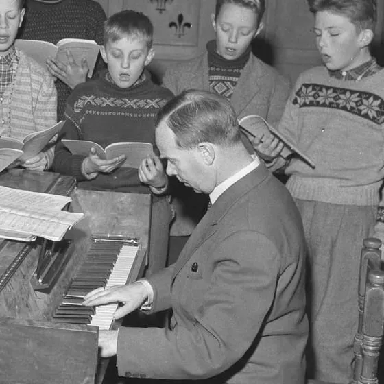 Ludvig Nielsen ved pianoet under en øvelse med guttekoret